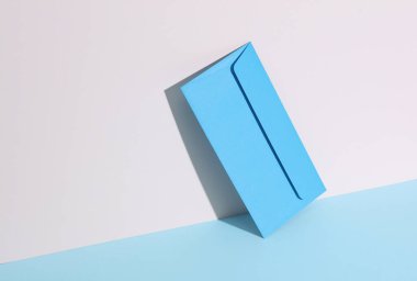 Pastel parlak arka planda mavi zarflı yaratıcı bir düzen. Minimalizm