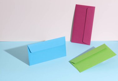 Pastel parlak arkaplanda renkli zarflar olan yaratıcı bir düzen. Minimalizm