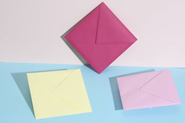 Pastel parlak arkaplanda renkli zarflar olan yaratıcı bir düzen. Minimalizm