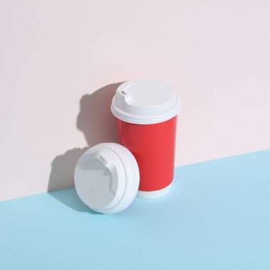 Sıcak içecekler için beyaz kapaklar ve pastel arka planda gölgeli karton bardak. Yaratıcı düzen, minimalizm