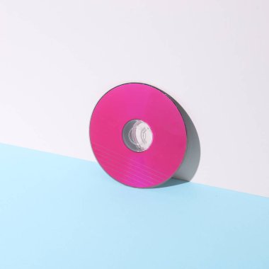 Yaratıcı düzen. Pastel arka planda pembe CD disk