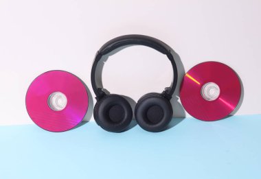 Yaratıcı düzen. Pastel arka planda stereo kulaklıklı pembe CD diskler. Müzik konsepti