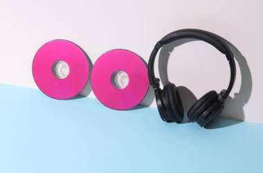Yaratıcı düzen. Pastel arka planda stereo kulaklıklı pembe CD diskler. Müzik konsepti