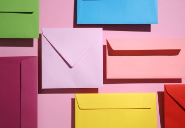 Pastel arka planda gölgeli birçok renkli zarf var. Minimum konsept. Yaratıcı renk düzeni. Üst görünüm