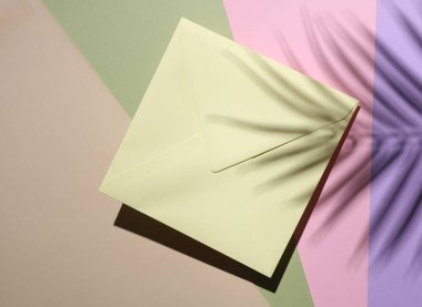 Marka modeli. Pastel arka planda palmiye yaprakları olan kare kağıt.