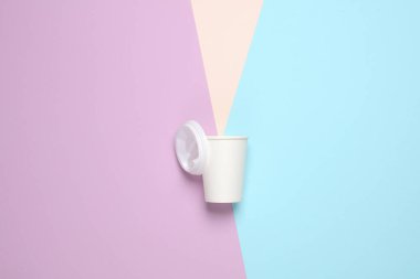 Pastel arka planda tek kullanımlık beyaz bir bardağın yaratıcı düzeni