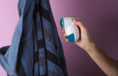 Mor arka planda temizleme topakları ve kazak için el tutma aygıtı