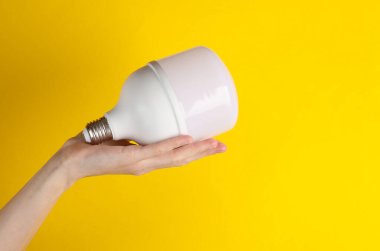 Elektrik tasarrufu. Sarı arkaplanda büyük bir ampul var.