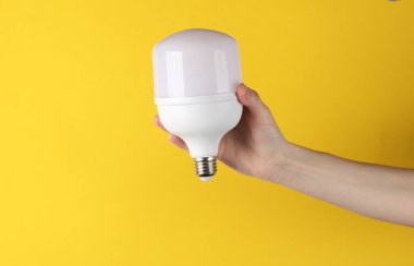 Elektrik tasarrufu. Sarı arkaplanda büyük bir ampul var.