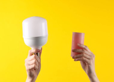 Alternatif aydınlatma. Sarı arka planda ellerinde lamba ve mum vardı.