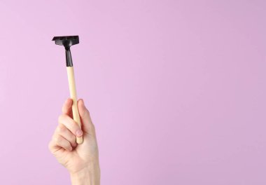 Mor arka planda küçük bahçe aletleri (tırmık)