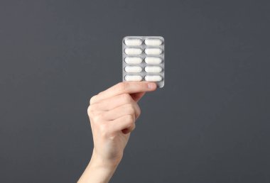 Koyu gri arka planda el ele tutuşan su toplayan haplar.