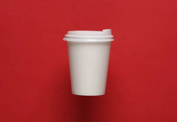 Mockup of white disposable cup with lids for hot drinks on red background