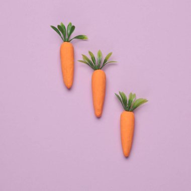 Pastel arka planda plastik havuç. Asgari, kavramsal gıda natürmort, yaratıcı düzen