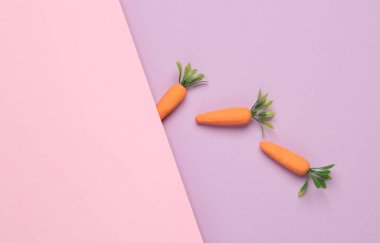 Pastel arka planda plastik havuç. Asgari, kavramsal gıda natürmort, yaratıcı düzen