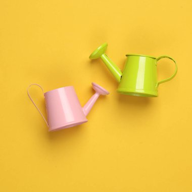 Sarı arka planda minyatür sulama kutuları. Yaratıcı yerleşim