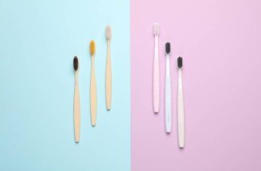 Pastel arka planda plastik ve eko bambu diş fırçaları. Üst görünüm