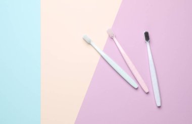Pastel arka planda iki plastik diş fırçası. Ağız temizliği.