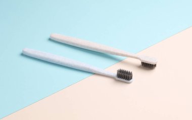 Pastel arka planda iki plastik diş fırçası. Ağız temizliği.