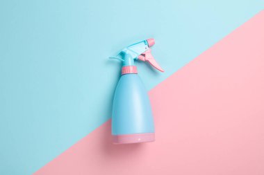 Pastel arka planda mavi-pembe plastik sprey şişesi. Üst Manzara. Minimalizm