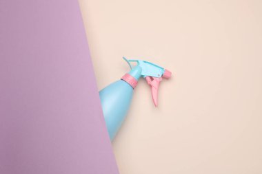 Pastel arka planda mavi-pembe plastik sprey şişesi. Üst Manzara. Minimalizm