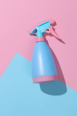 Pastel arka planda mavi-pembe plastik sprey şişesi. Üst Manzara. Minimalizm