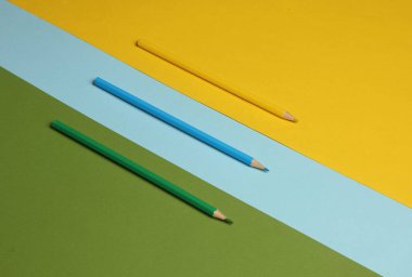 Renkli arka planda üç renkli kalem. Minimalizm