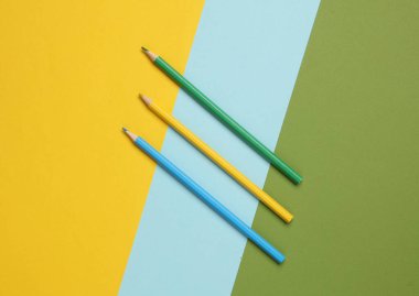 Renkli arka planda üç renkli kalem. Minimalizm