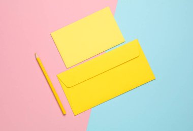 Sarı tebrik kartı, pembe mavi arka planda zarf ve kalem.