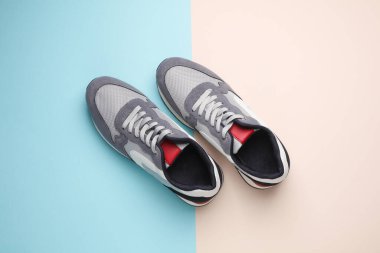 Pastel arka planda gri koşu ayakkabıları. Sıradan spor ayakkabılar. Üst görünüm