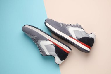 Pastel arka planda gri koşu ayakkabıları. Sıradan spor ayakkabılar. Üst görünüm