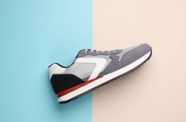 Pastel arka planda gri koşu ayakkabısı. Sıradan bir spor ayakkabı. Üst görünüm