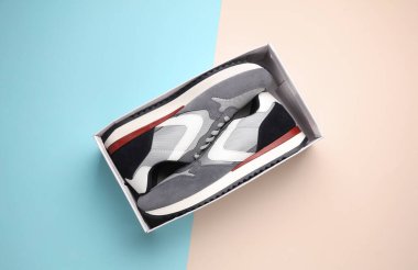 Pastel arka planda kutulu yeni gri koşu ayakkabıları. Sıradan spor ayakkabılar..