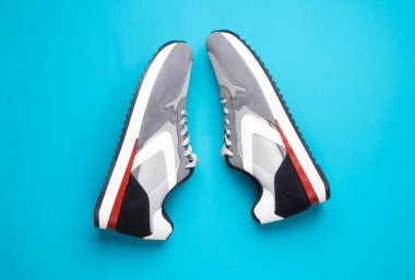 Mavi arka planda gri koşu ayakkabıları. Sıradan spor ayakkabılar. Üst görünüm