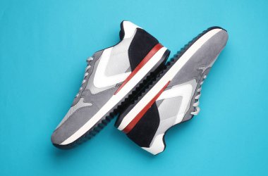 Mavi arka planda gri koşu ayakkabıları. Sıradan spor ayakkabılar. Üst görünüm