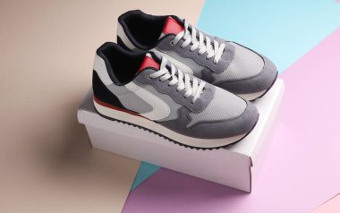 Pastel arka planda kutulu yeni gri koşu ayakkabıları. Sıradan spor ayakkabılar..