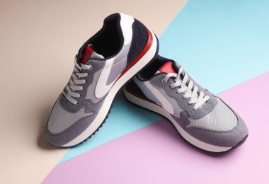 Pastel arka planda gri koşu ayakkabıları. Sıradan spor ayakkabılar..