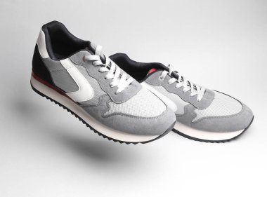 Gri arka planda gölgeli gri spor ayakkabılar