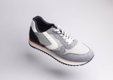 Gri arka planda gölgeli gri spor ayakkabısı