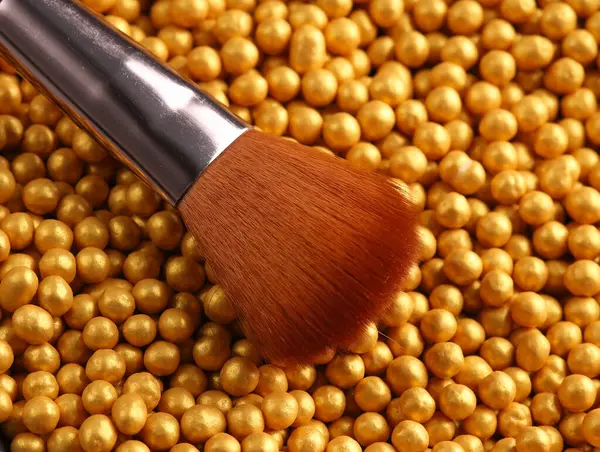 Makeup brush on Bronze make up powder balls. Beauty concept