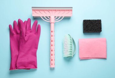 Temizlik için aksesuarlar. Cam temizleme bezi, eldivenler, sünger, fırça, mavi bir arka plan. Üst görünüm