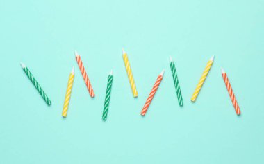 Mavi pastel arka planda renkli doğum günü mumları. Minimalizm partisi konsepti