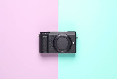 Mavi-pembe renkli arka planda modern dijital aynasız kamera. Üst Manzara. Minimalizm