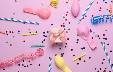 Pastel arka planda hediye kutuları, konfeti, mum ve balonlar. Doğum günü, parti konsepti. Üst görünüm