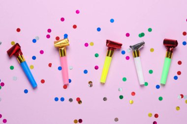 Pembe arka planda konfetili doğum günü boynuzları. Parti konsepti