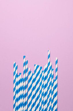 Pembe arka planda mavi kağıt pipetler. Parti, doğum günü aksesuarları