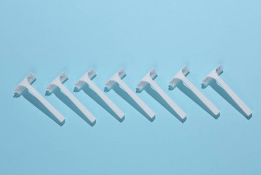 Mavi arka planda tek kullanımlık plastik jiletler. Üst Manzara. Yaratıcı yerleşim