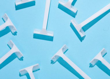 Mavi arka planda tek kullanımlık plastik jiletler. Üst Manzara. Yaratıcı yerleşim