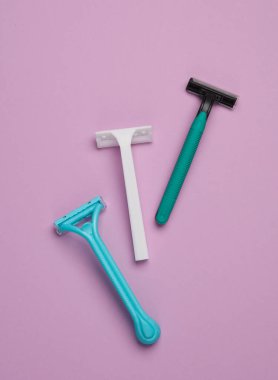 Pastel arka planda tek kullanımlık plastik jiletler, güzellik konsepti. Üst Manzara. Yaratıcı yerleşim