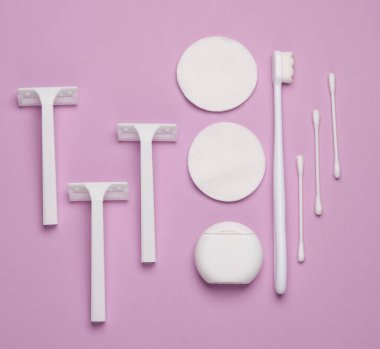 Pamuk yastıklı ve sopalı beyaz jiletler, pastel arka planda diş fırçası. Temizlik, güzellik konsepti. Üst Manzara. Düz yatıyordu